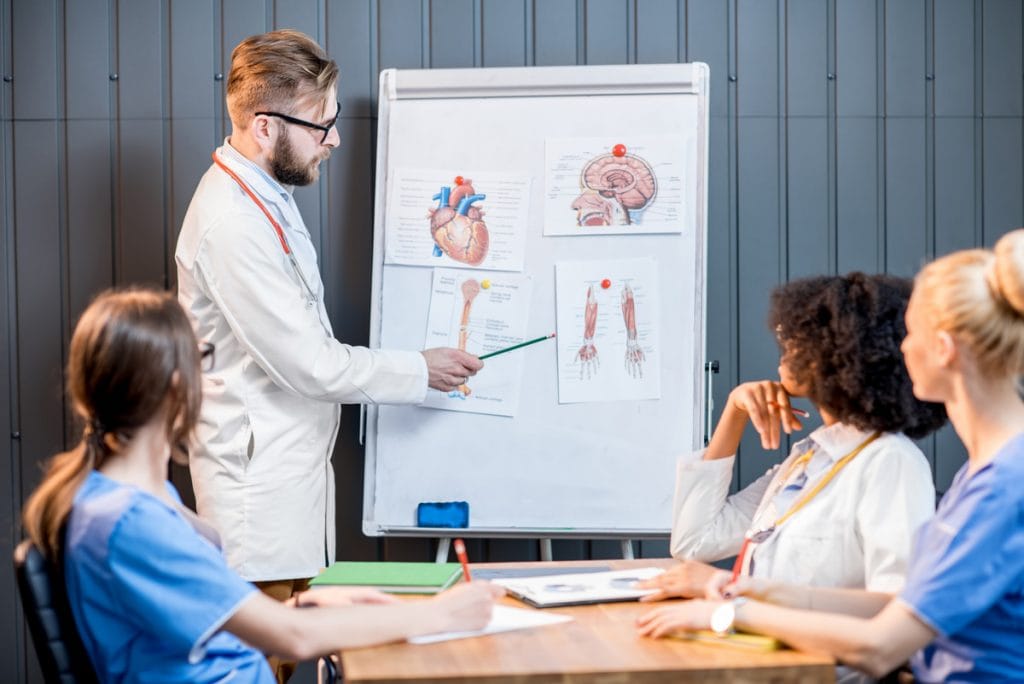 multi-ethnic-medics-having-conference-with-white-board-modern-office-1